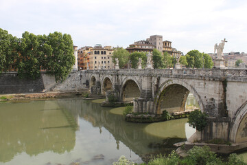 Fototapeta na wymiar Bridge over the Tiber river with marble sculptures in downtown Rome, Italy