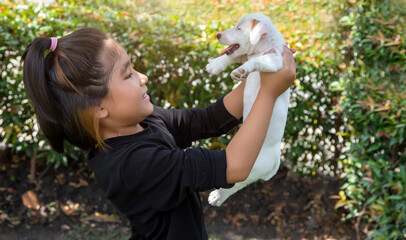 Obraz premium happy friendship asian girl love and hug puppy dog