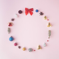 Naklejka na ściany i meble A circle made of Christmas decorations on a pink background. Minimal Christmas composition.