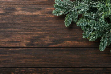 Christmas fir tree branches, Christmas balls, gift box, wooden snowflakes and stars on old brawn wooden background for your xmas greetings. Top view with copy space. Christmas greeting card.