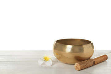 Golden singing bowl, mallet and flower on wooden table against white background, space for text