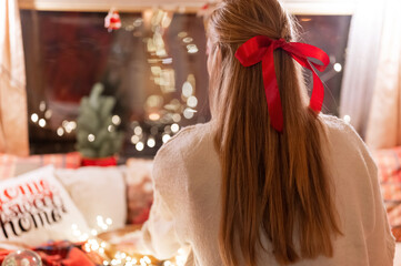 faceless woman with long blondie hair and red bow hair clip enjoyment relaxing at home in cozy...
