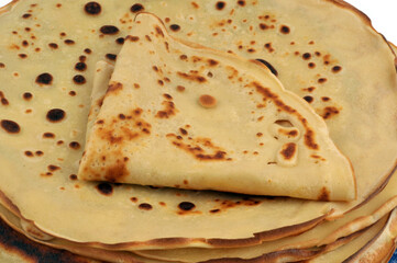 Crêpe pliée en triangle posée sur une pile de crepes en gros plan