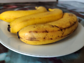 Overripe bananas with dark marks on a plate