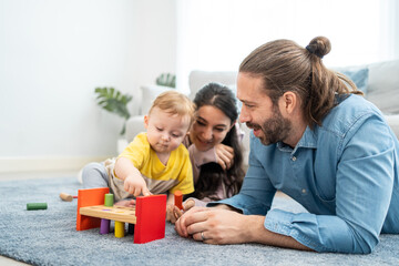 Caucasian happy loving parent play with baby toddler in living room. 