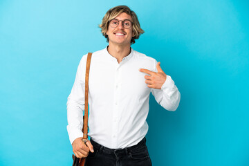 Young blonde businessman isolated on blue background with surprise facial expression
