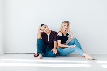a woman and a man friends stand side by side in a white room