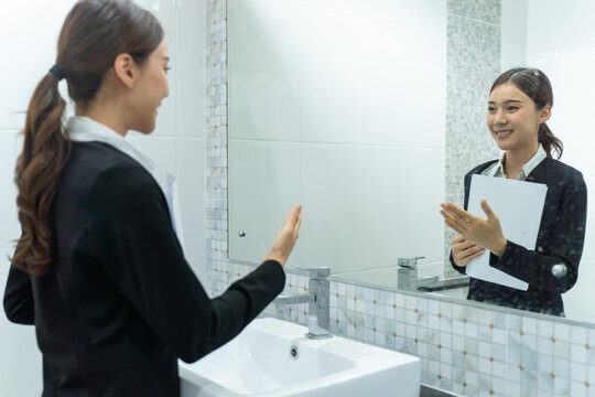 Asian applicant prepare for job interview in front of mirror at home.