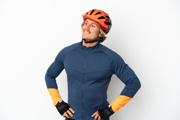 Young blonde cyclist man isolated on white background posing with arms at hip and smiling