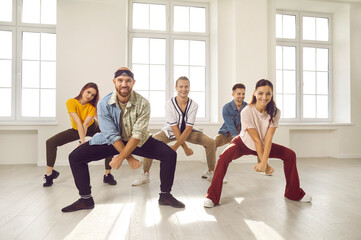 Group of happy, smiling young people having a dancing class. Cheerful, talented, beautiful, well-trained dancers in casual wear all together practising a new choreo in their light, sunny dance studio