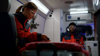 Health care professionals going for emergency call in ambulance car