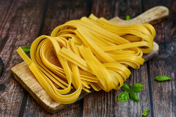 Raw fresh  uncooked tagliatelle egg pasta . Ready for cooking. Italian food concept. Kitchen poster