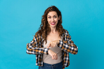 Young caucasian woman isolated on blue background making the gesture of being late