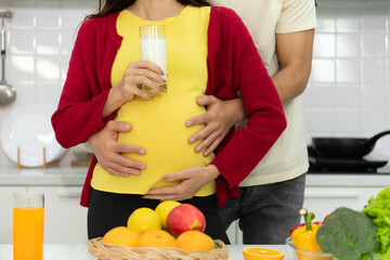 Pregnant woman in kitchen with the atmosphere of cooking with the husband to eat together