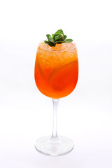 Cocktail in a tall glass transparent glass - orange colored drink with fruit orange, with green mint leaves. Diet delicious drink, healthy food, isolated
