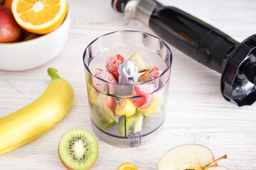 Hand blender and a table with ripe fruits in your home kitchen.