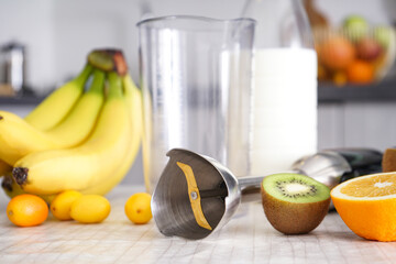 Home kitchen with ripe fruit table and hand blender, close-up.