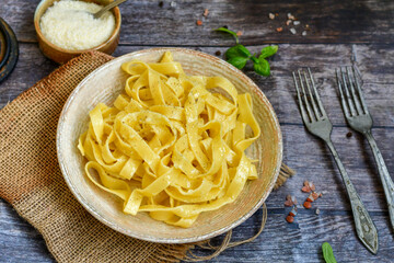 Italian food . Fresh home made  tagliatelle vegetarian  egg pasta  with ,parmesan cheese ,fresh parsley  and black pepper.Pasta cacio e pepe