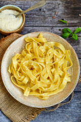 Italian food . Fresh home made  tagliatelle vegetarian  egg pasta  with ,parmesan cheese ,fresh parsley  and black pepper.Pasta cacio e pepe