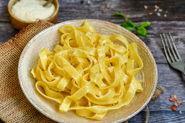 Italian food . Fresh home made  tagliatelle vegetarian  egg pasta  with ,parmesan cheese ,fresh parsley  and black pepper.Pasta cacio e pepe