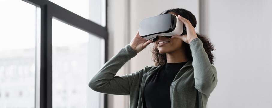 Young woman using virtual reality headset at home, VR, future, gadgets, technology, virtual event, education, study, learning, video game concept. Panoramic web banner