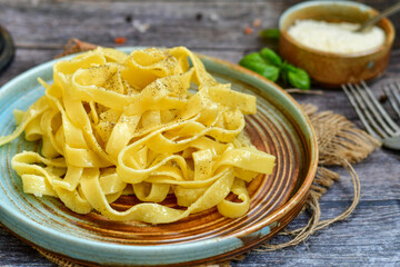 Italian food . Fresh home made  tagliatelle vegetarian  egg pasta  with ,parmesan cheese ,fresh parsley  and black pepper.Pasta cacio e pepe