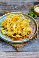 Italian food . Fresh home made  tagliatelle vegetarian  egg pasta  with ,parmesan cheese ,fresh parsley  and black pepper.Pasta cacio e pepe