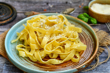 Italian food . Fresh home made  tagliatelle vegetarian  egg pasta  with ,parmesan cheese ,fresh parsley  and black pepper.Pasta cacio e pepe