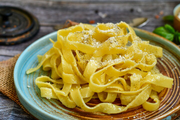 Italian food . Fresh home made  tagliatelle vegetarian  egg pasta  with ,parmesan cheese ,fresh parsley  and black pepper.Pasta cacio e pepe