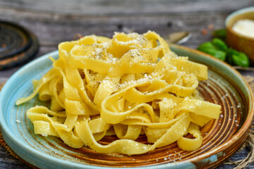 Italian food . Fresh home made  tagliatelle vegetarian  egg pasta  with ,parmesan cheese ,fresh parsley  and black pepper.Pasta cacio e pepe