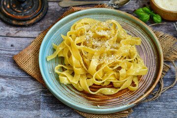 Italian food . Fresh home made  tagliatelle vegetarian  egg pasta  with ,parmesan cheese ,fresh parsley  and black pepper.Pasta cacio e pepe