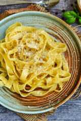 Italian food . Fresh home made  tagliatelle vegetarian  egg pasta  with ,parmesan cheese ,fresh parsley  and black pepper.Pasta cacio e pepe