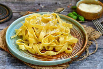 Italian food . Fresh home made  tagliatelle vegetarian  egg pasta  with ,parmesan cheese ,fresh parsley  and black pepper.Pasta cacio e pepe