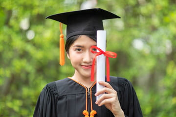 Attractive Asian Women Student Graduate in cap and gown celebrating with certificate in hand and so proud happiness in Commencement day,Congratulation of student in graduation day,Education Success