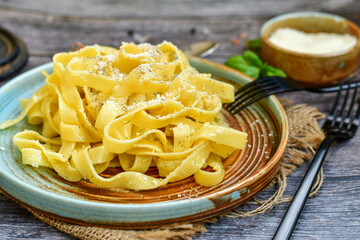Italian food . Fresh home made  tagliatelle vegetarian  egg pasta  with ,parmesan cheese ,fresh parsley  and black pepper.Pasta cacio e pepe