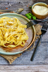 Italian food . Fresh home made  tagliatelle vegetarian  egg pasta  with ,parmesan cheese ,fresh parsley  and black pepper.Pasta cacio e pepe