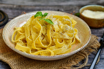 Italian food . Fresh home made  tagliatelle vegetarian  egg pasta  with ,parmesan cheese ,fresh parsley  and black pepper.Pasta cacio e pepe