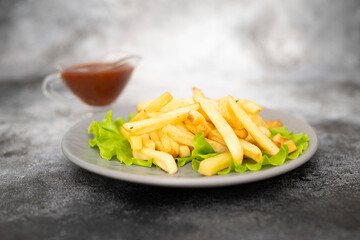 french fried potatoes on the grey plate. horizontal view.