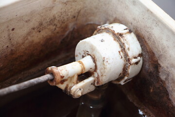 Old dirty water fill valve in empty drain water tank closeup - DIY WC maintenance at home