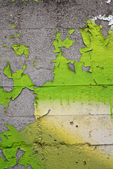 green paint peeling on stone wall