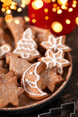  Festive Christmas cookies decorated with icing and powdered sugar on a plate close up, soft focus, vertical photo