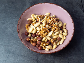 Mix nuts on a wooden background.