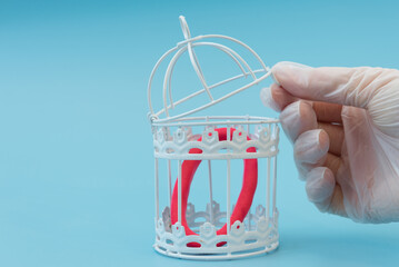 A hand in a medical glove places the omicron virus in a cage. The concept of victory over the...