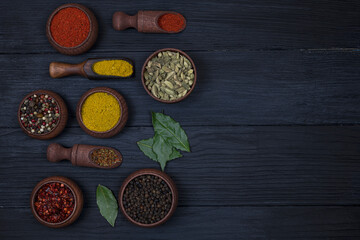 Fototapeta na wymiar Assortment of Spices on a Black Wooden Background. Space for text. Top view.