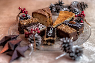 Variety of desserts chocolate coffee cake brownie apple pie on a glass plate with pine cones and...