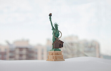 Statue of Liberty with new home keys. New York real estate concept with cityscape on background....