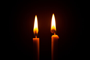 Two big burning candles. Bright light on dark background. RIP darkness template. Birthday party. Romantic evening on Valentine