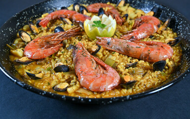 Seafood and rice paella with prawns close up