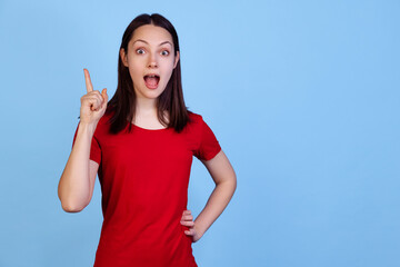 Half-length portrait of cute pretty young woman in red t-shirt isolated on blue studio background....