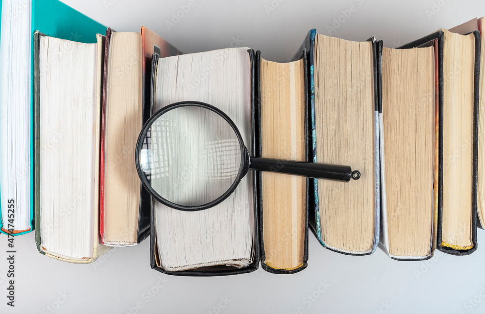 Poster magnifying lens over books row with lot of pages. concept of knowledge and studying.